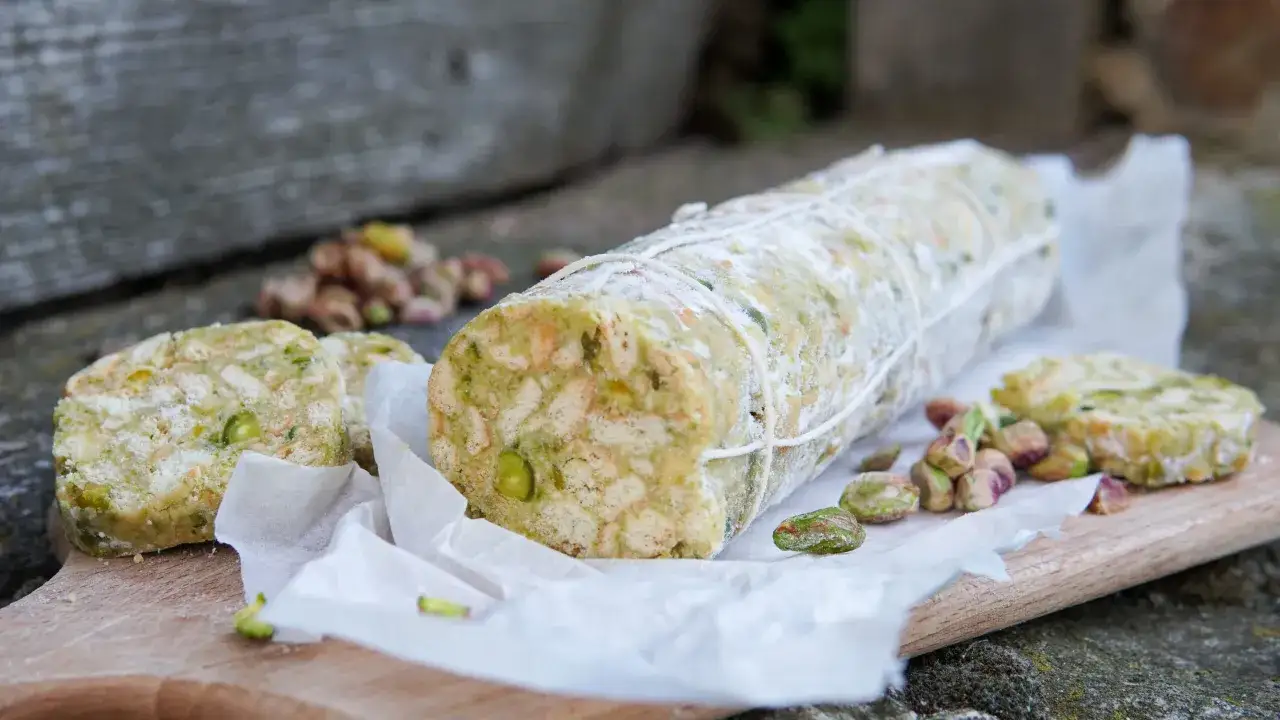 Salame di cioccolato con pistacchi, un dolce rustico e goloso, pronto per essere affettato.