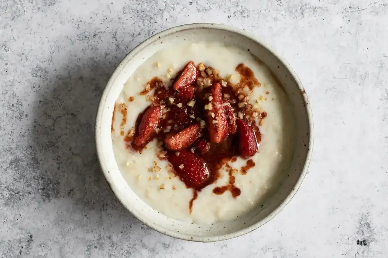 Porridge ricetta: cremosa avena con fragole caramellate, noci tritate e un filo di sciroppo.