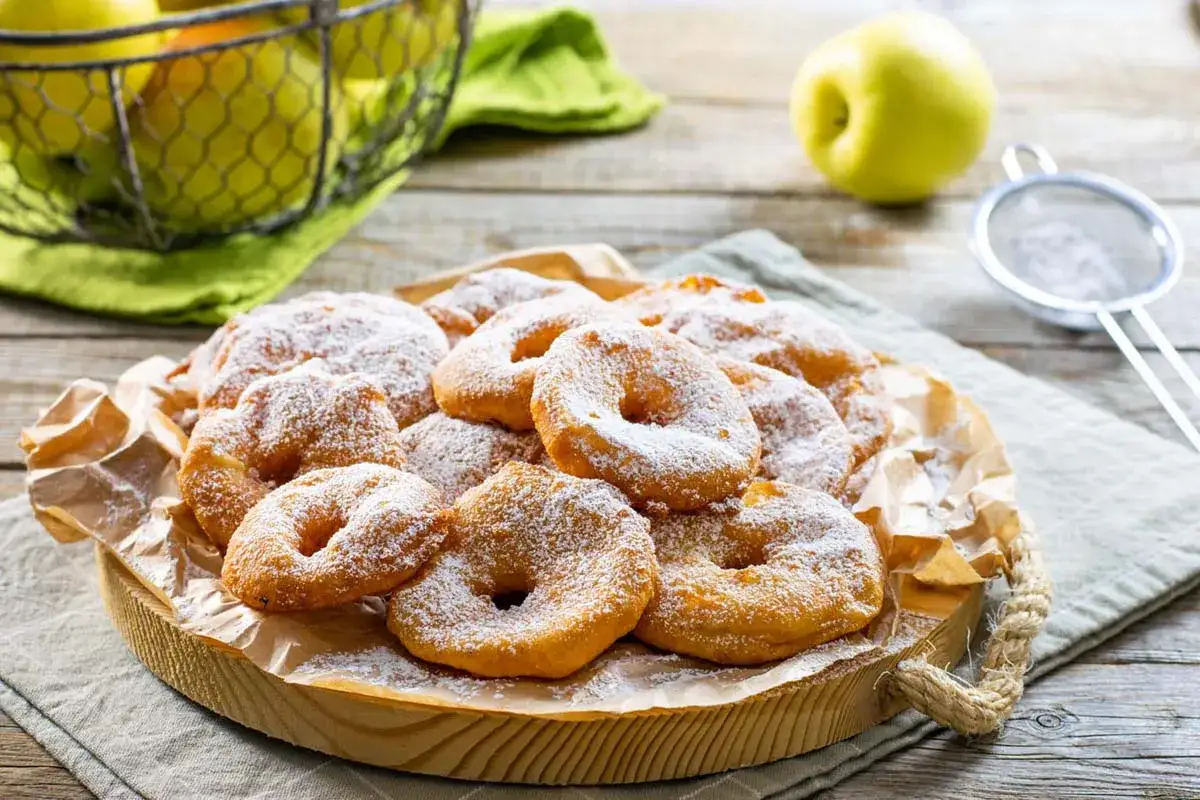 Frittelle di mele della nonna, dorate e soffici, cosparse di zucchero a velo. Un dolce che profuma di casa e ricordi.