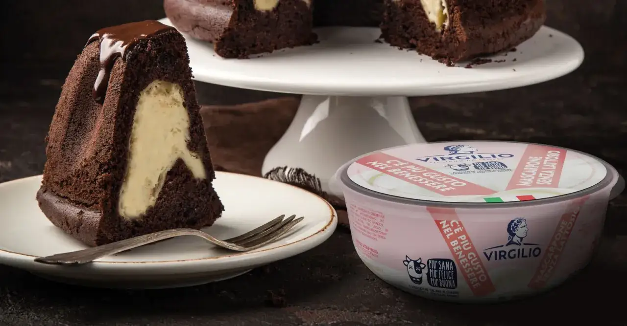 Fetta di torta al cacao con cuore cremoso di mascarpone. Accanto, una confezione di mascarpone Virgilio senza lattosio.