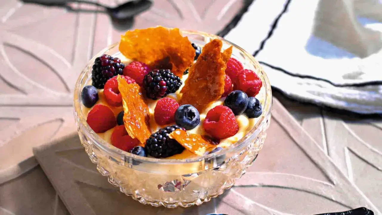 Coppa di crema con frutti di bosco freschi e croccante caramello. Un'idea per dolci veloci e golosi.