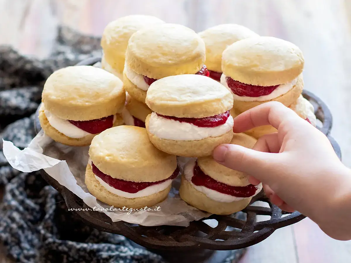 Deliziosi scones con panna e marmellata, pronti per essere gustati. Una ricetta perfetta per la colazione o la merenda.