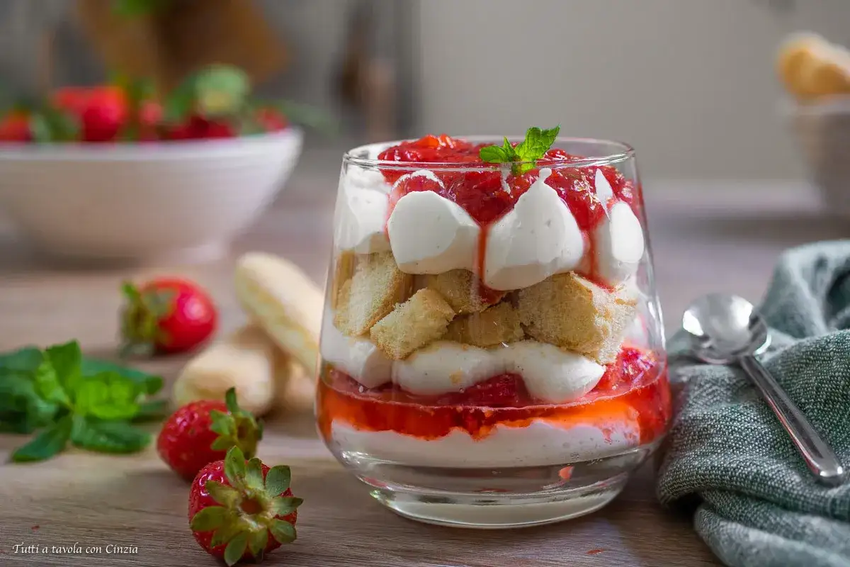 Delizioso tiramisù alle fragole in un bicchiere, con strati di crema, savoiardi e fragole fresche.