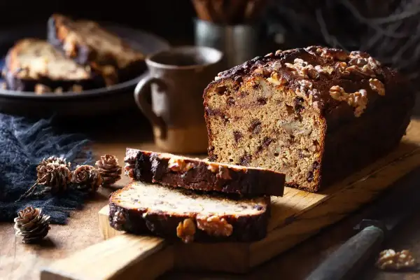 Plumcake noci e cioccolato, con fette tagliate e noci intere sparse. Un'atmosfera rustica e invitante.