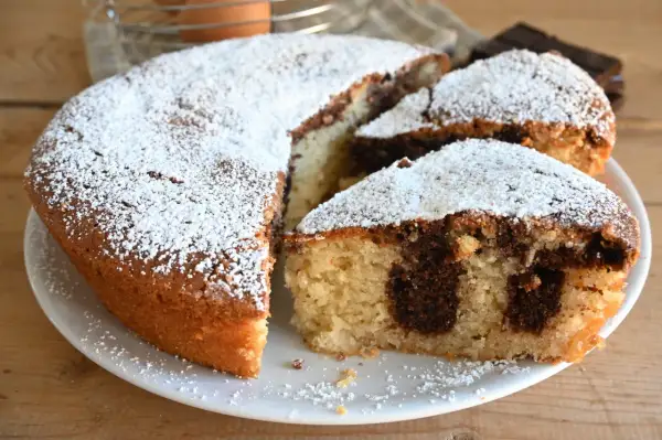 Torta variegata con zucchero a velo, un classico che conquista con il suo contrasto di sapori e la sua morbidezza.