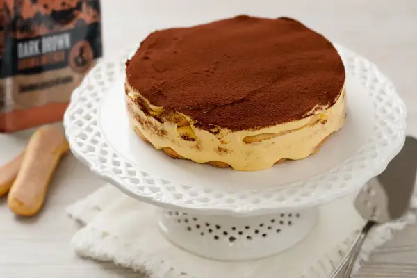 Tiramisù pronto, con savoiardi e crema, spolverato di cacao. Gli ingredienti tiramisù sono pronti per essere gustati.