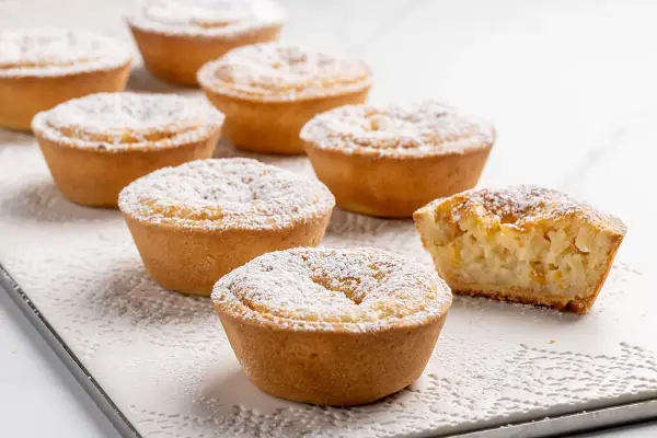 Piccoli dolci veloci, crostate con ripieno cremoso e spolverata di zucchero a velo, perfetti per una pausa golosa.