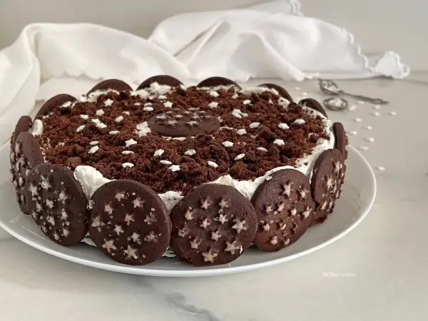 Torta Pan di Stelle decorata con biscotti al cacao e stelline bianche, un dolce che fa sognare.