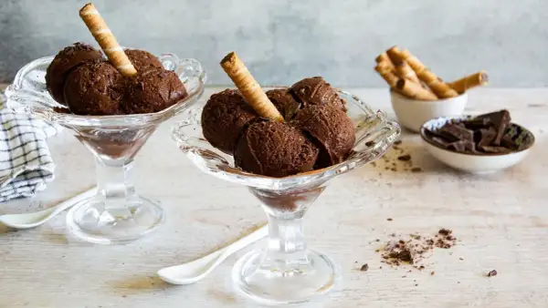Coppette di granita al cioccolato, guarnite con cialde e scaglie di cioccolato.