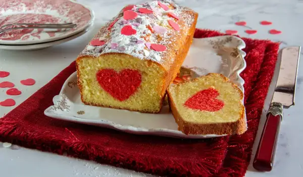 Plumcake farcito con un cuore rosso al centro, decorato con zuccherini a forma di cuore.